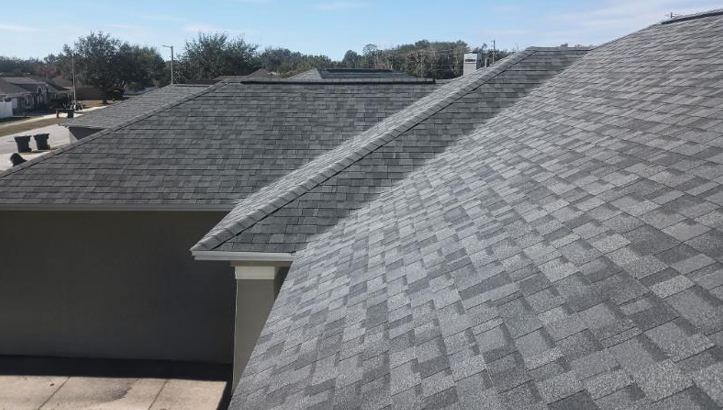 A gray asphalt shingled rooftop corner.